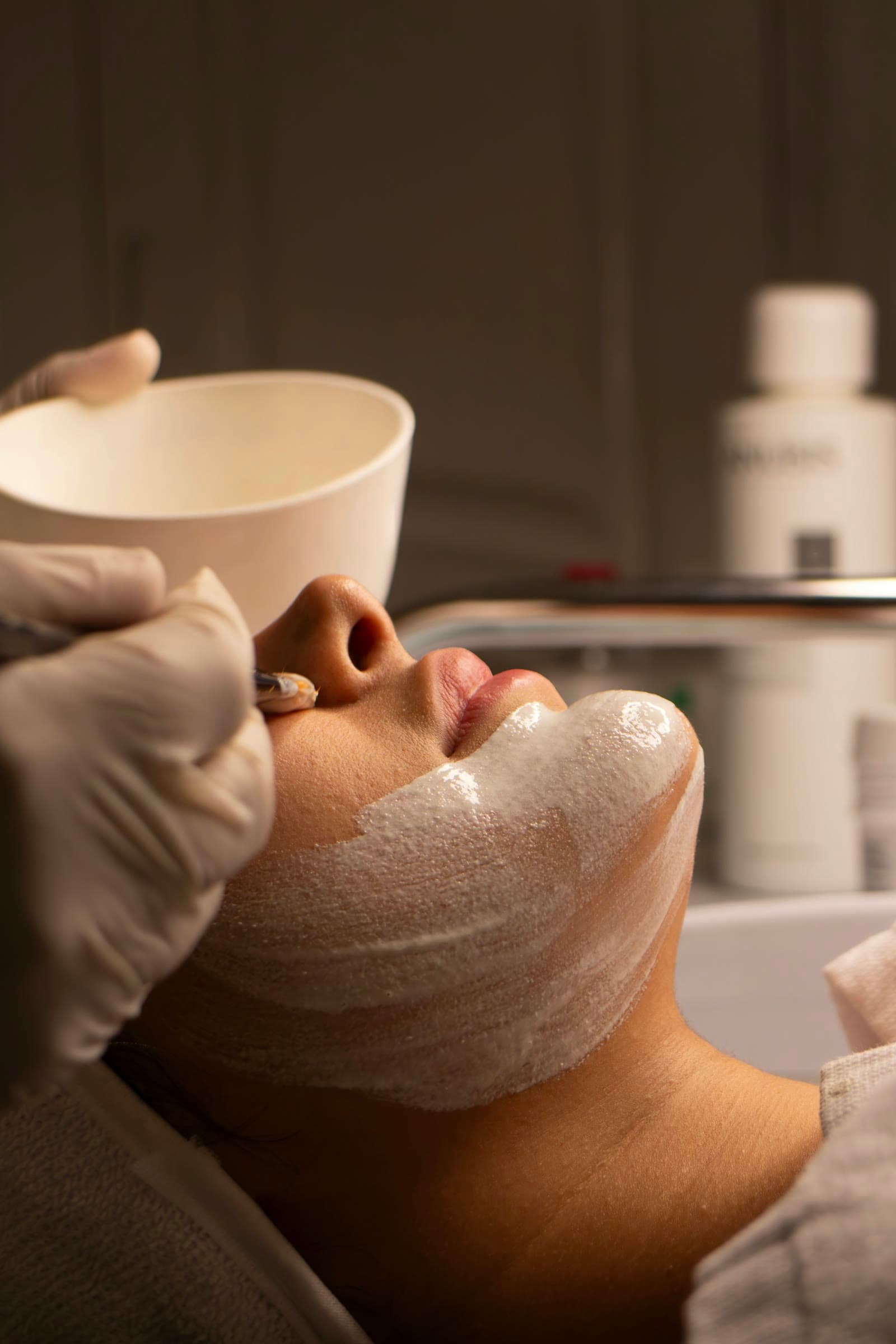 Gloved hands applying a treatment mask
